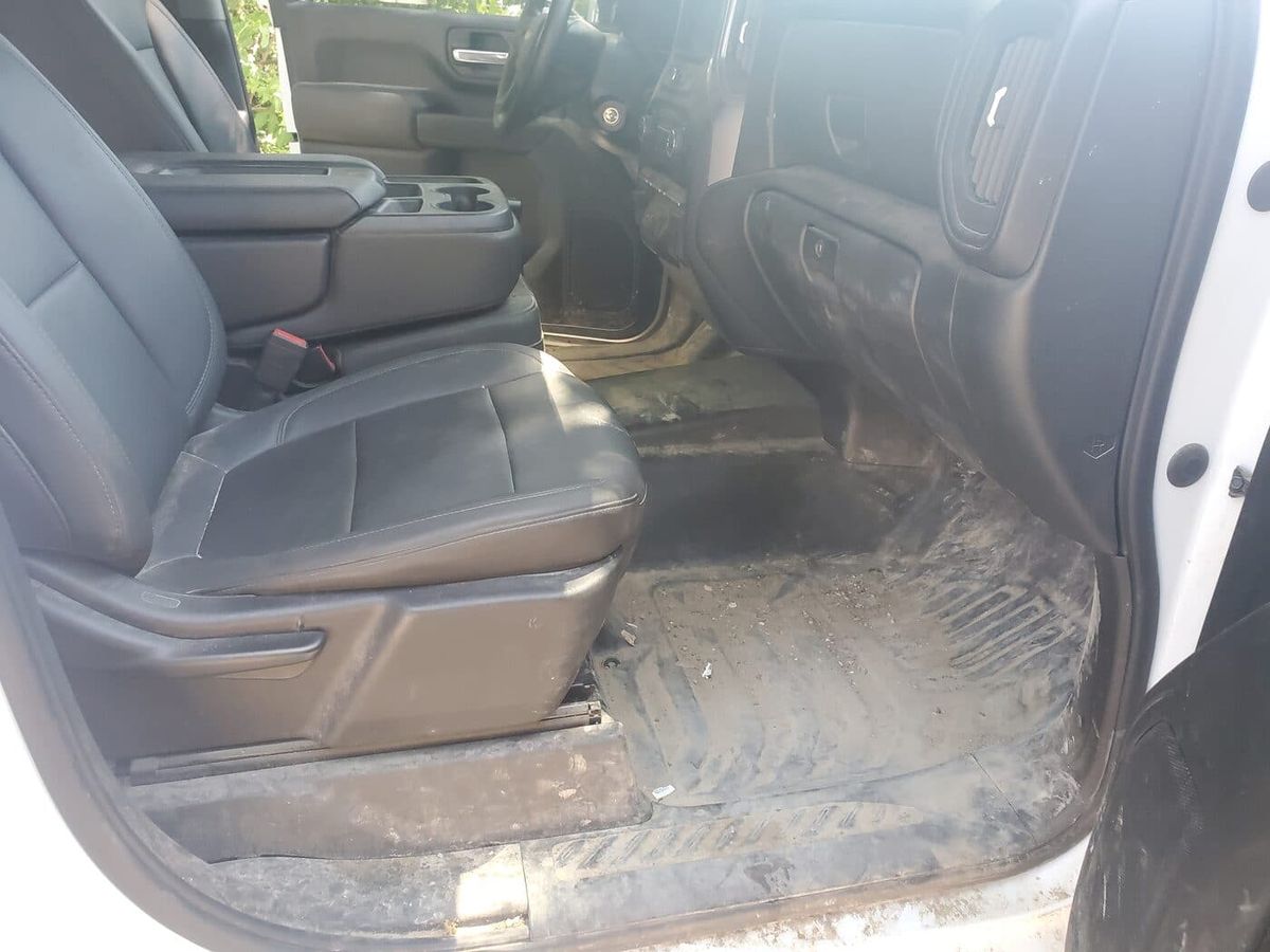 Driver seat and muddy floor mat before an interior deep clean